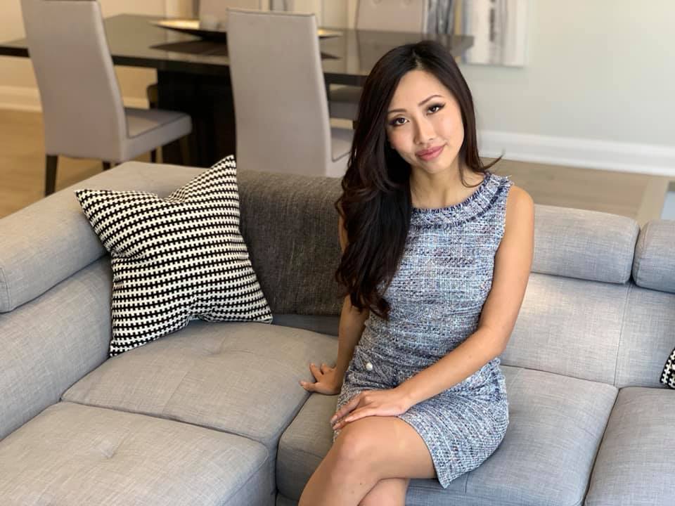 Anna Tran, Real Estate Broker sitting on a couch